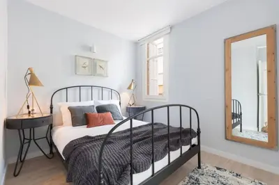 a bedroom with a black bed and a mirror at 2 Bdr Penthouse In Grcia in Barcelona
