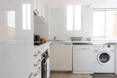 a white kitchen with a washer and dryer at 2 Bdr Penthouse In Grcia in Barcelona