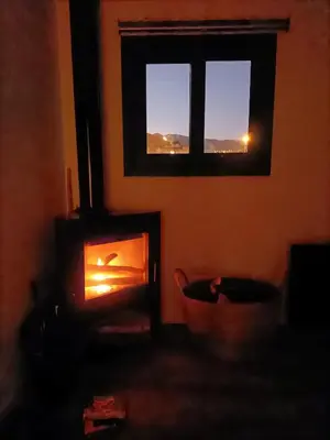 a living room with a fire burning in a fireplace at Atico duplex Playa Area barcelona con SPA exterior in Montgat