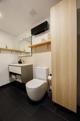 a bathroom with a white toilet and a sink at Atico duplex Playa Area barcelona con SPA exterior in Montgat