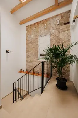 a staircase with a brick wall and a potted plant at Atico duplex Playa Area barcelona con SPA exterior in Montgat