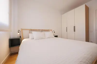 a bedroom with a large white bed with two pillows at Atico duplex Playa Area barcelona con SPA exterior in Montgat