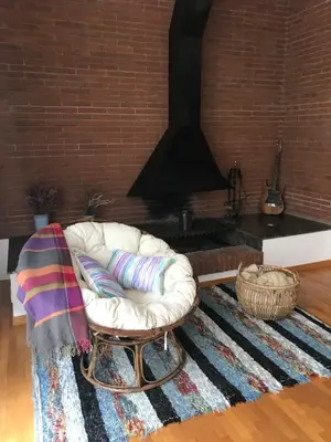 a living room with a white chair and a fireplace at Gran apartamento de 4 habitaciones en Sitges in Sitges