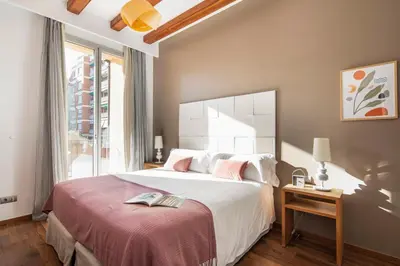 a bedroom with a large white bed and a window at Aspasios Market Balconies Apartments in Barcelona