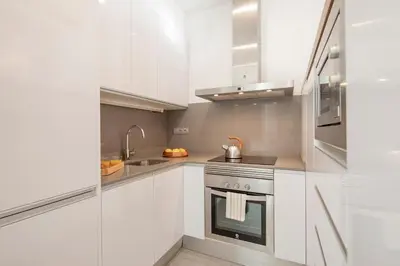 a white kitchen with a stove and a sink at Aspasios Market Balconies Apartments in Barcelona