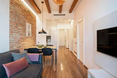 a living room with a couch and a brick wall at Aspasios Market Balconies Apartments in Barcelona