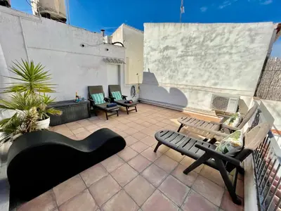 a patio with benches and chairs on a roof at Sea Dreams with Amazing Terrace in Sitges