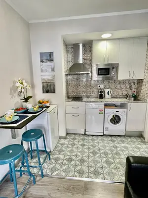 a kitchen with white cabinets and a table and chairs at Sea Dreams with Amazing Terrace in Sitges