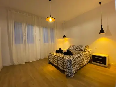 a bedroom with a bed with two cats sitting on it at Casa adosada a 20 min centro de Barcelona in Hospitalet de Llobregat