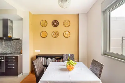 a dining room with a table with chairs and plates on the wall at FORUM BEACH 2 AND POOL APARTMENT BARCELONA in Sant Adria de Besos
