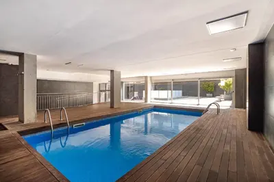 a swimming pool with blue water in a building at FORUM BEACH 2 AND POOL APARTMENT BARCELONA in Sant Adria de Besos