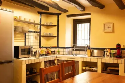 a kitchen with a table and a refrigerator at Masia en plena naturaleza y tranquilidad in San Quintín de Mediona