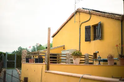 a yellow house with potted plants on a balcony at Masia en plena naturaleza y tranquilidad in San Quintín de Mediona