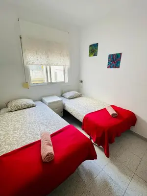 two beds in a room with red sheets at Barca 1 in Sant Adria de Besos