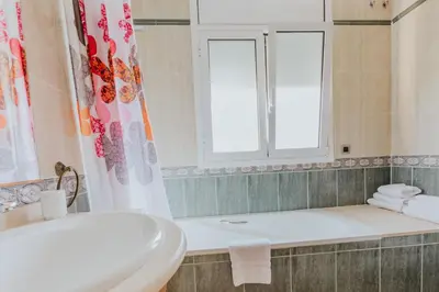 a bathroom with a tub and a sink and a window at Collbato Resort. in Collbató