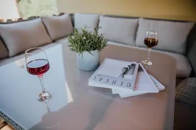 two glasses of wine on a table with a couch at Collbato Resort. in Collbató