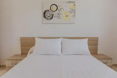 a bedroom with a white bed with two pillows at Collbato Resort. in Collbató