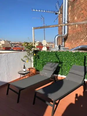 a patio with two chairs and a table on a roof at Attic Apartment 468 Sagrada Familia in Barcelona