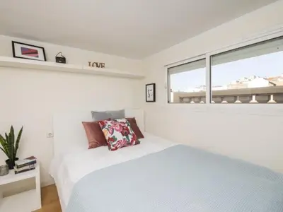 a white bedroom with a bed and a window at Attic Apartment 468 Sagrada Familia in Barcelona