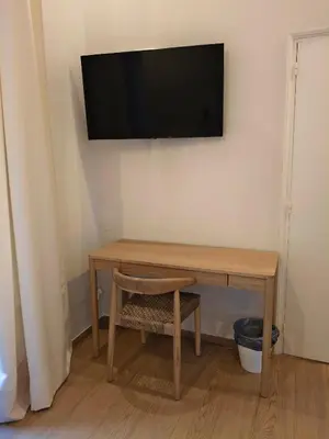 a wooden table with a television on a wall at Casa Consell Bailen, Guest House in Barcelona