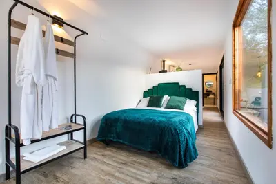 a bedroom with a green bed and a mirror at Cabaña del Bosque in Canyelles