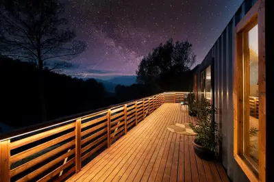 a wooden deck with a view of the night sky at Cabaña del Bosque in Canyelles