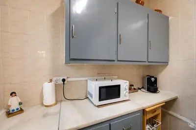 a kitchen counter with a microwave on top of it at Casa turística Cunit in Cunit