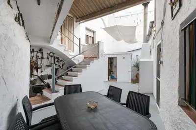 a dining room with a table and chairs and stairs at Casa turística Cunit in Cunit