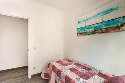 a bedroom with a bed and a painting on the wall at Barca 3 New Lovely aprtment Near Beach in Sant Adria de Besos