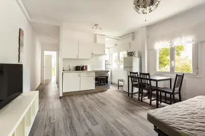 a kitchen and living room with a table and chairs at Barca 3 New Lovely aprtment Near Beach in Sant Adria de Besos