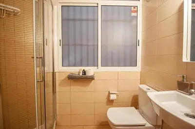 a bathroom with a toilet and a sink and a window at Apartamento zona Sagrada Familia in Barcelona