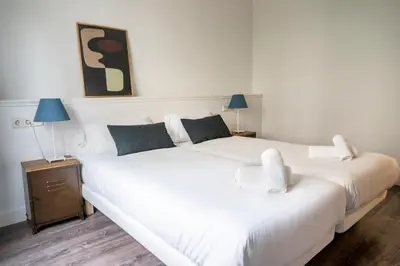 two white beds in a room with two lamps at Casa Cosi - Casanova 2 in Barcelona