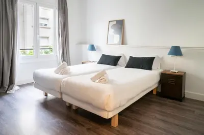 two beds in a white room with a window at Casa Cosi - Casanova 2 in Barcelona