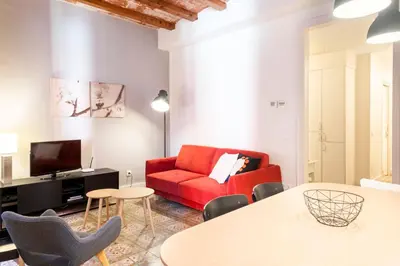 a living room with a red couch and a table at Casa Cosi - Putxet 3 in Barcelona