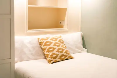 a white couch with a pillow on top of it at Casa Cosi - Sant Gervasi 3 in Barcelona