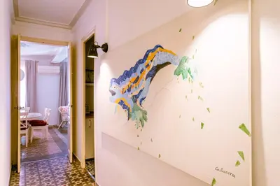 a painting on a wall in a hallway with green leaves at Casa Cosi - Sant Gervasi 3 in Barcelona