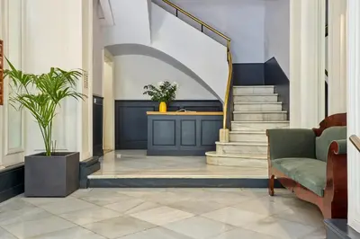 a lobby with a staircase with a chair and a couch at Casa Cosi - Terrace 1 in Barcelona