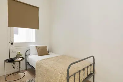 a small bedroom with a bed and a table at Casa Cosi - Casanova 3 in Barcelona