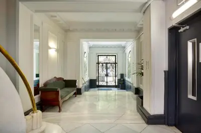 a hallway with a green chair and a door at Casa Cosi - Casanova 3 in Barcelona