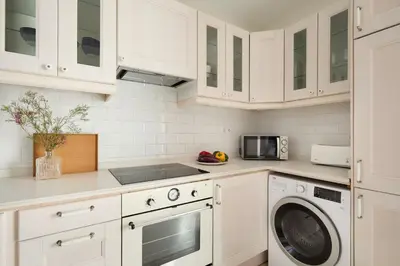 a kitchen with white cabinets and a washer and dryer at Casa Cosi - Terrace 2 in Barcelona