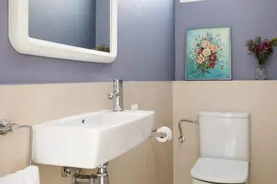 a bathroom with a sink and a toilet and a mirror at Casa Cosi - Terrace 2 in Barcelona