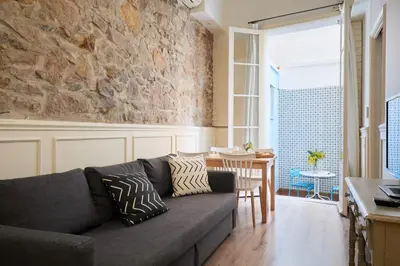 a living room with a couch and a stone wall at Casa Cosi - Patio 2 in Barcelona