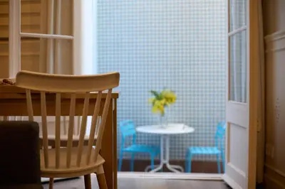 a chair and a table with a vase of flowers in a room at Casa Cosi - Patio 2 in Barcelona