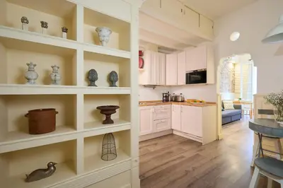 a kitchen with white cabinets and white shelves at Casa Cosi - Patio 2 in Barcelona