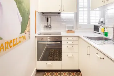 a white kitchen with a stove and a sink at Casa Cosi - Putxet 1 in Barcelona
