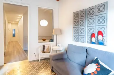 a living room with a blue couch and a hallway at Casa Cosi - Putxet 1 in Barcelona