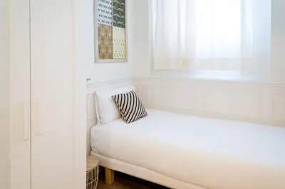 a white room with a bed and a window at Casa Cosi - Putxet 1 in Barcelona