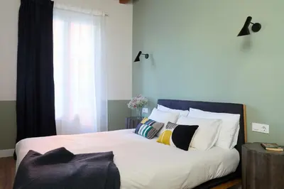 a bedroom with a large bed with white sheets and pillows at Casa Cosi - Putxet 2 in Barcelona