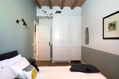 a bedroom with a white bed and a white closet at Casa Cosi - Putxet 2 in Barcelona