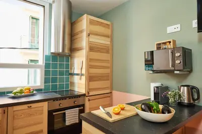 a kitchen with wooden cabinets and a bowl of fruit on a counter at Casa Cosi - Putxet 2 in Barcelona